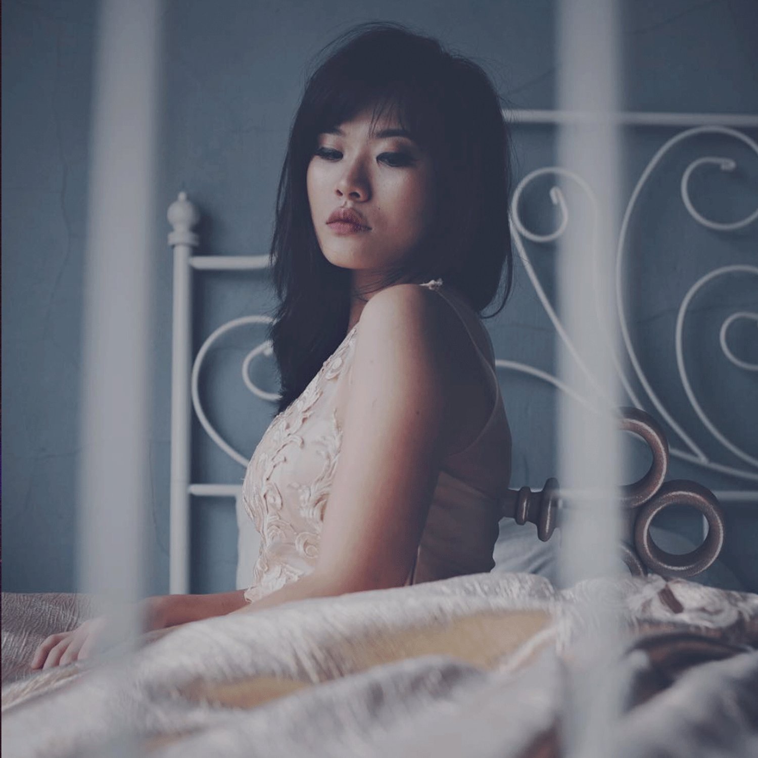 Absconding Reality, plate XVIII: a woman in a lace slip sitting on a bed behind white iron bars