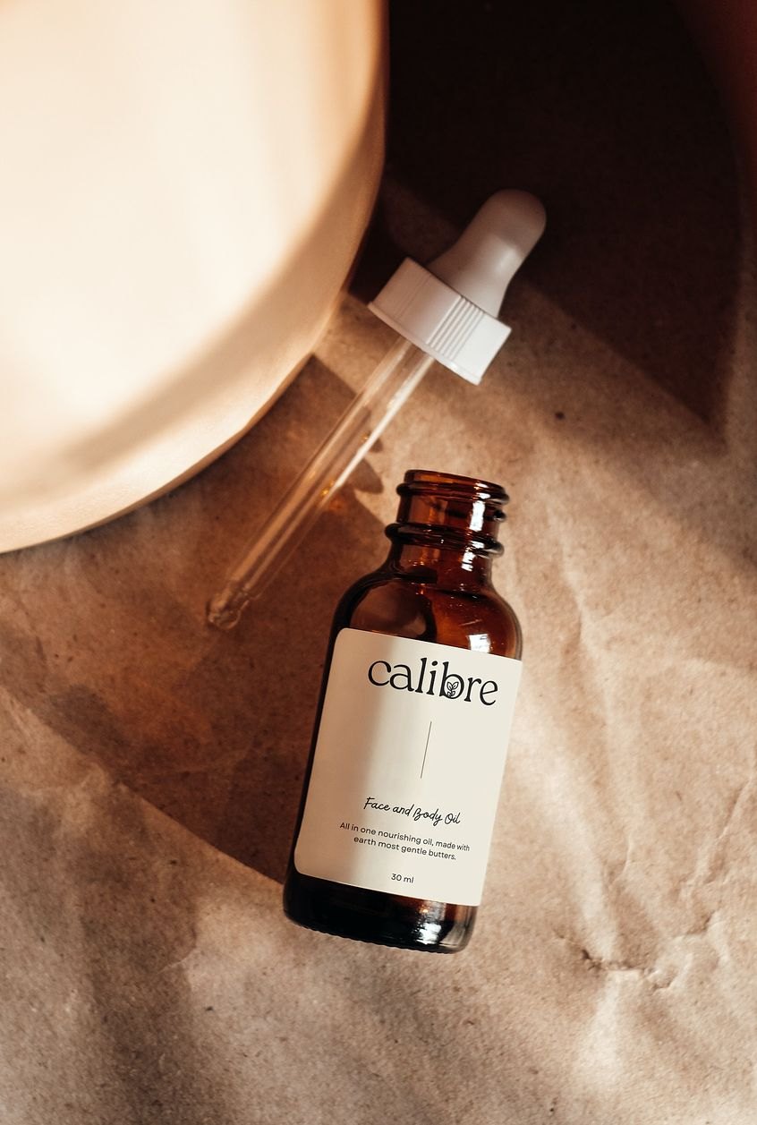 Amber dropper bottle of Calibre face oil on crinkled kraft paper