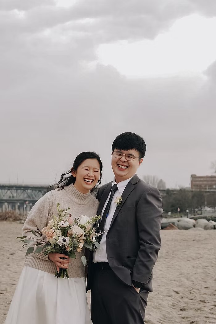 Smiling couple with a bouquet on the beach