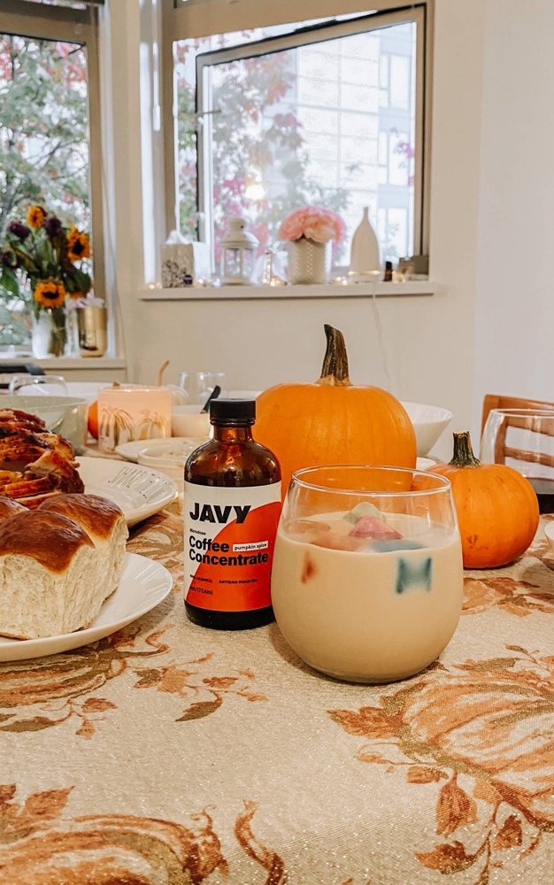 Javy Coffee iced coffee on an autumn table with pumpkins and pastries